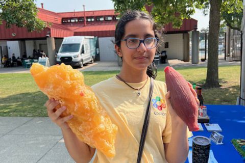 Simran Adnani hold an ear of corn and a blob of fat. 