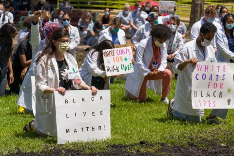 people in white coats kneeling 