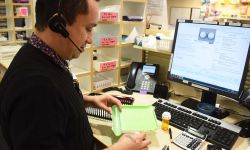 man by his desk with pills