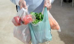 Close up on person buyer hold groceries in bags. 