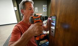 man putting new locks on doors