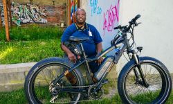 A man sitting next to his e-bike 