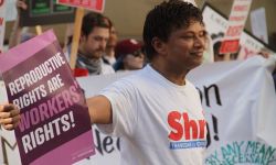 U.S. Rep. Shri Thanedar holding up a sign in a crowd