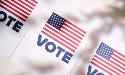 Vote signs with an American flag on a white wall