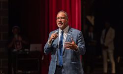 U.S. Secretary of Education Miguel Cardona speaks into a microphone on Cass Technical High School in Detroit 