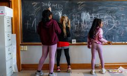 Kids writing on a chalkboard at school