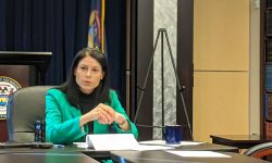 Michigan Attorney General Dana Nessel sits a table 