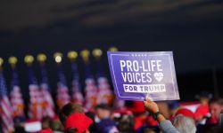 A person holding a sign that says "Pro-Life Voices for Trump"