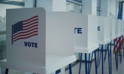 Voting booths with American flag logo in bright polling station office. 