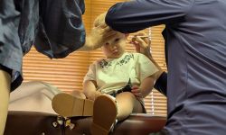 A toddler sits down during Dr. Cheryl Canfield's examination 