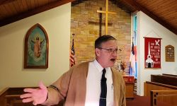 Rock River Township Clerk Tom Schierkolk in front of a church