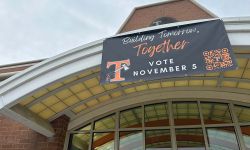 A sign on top of a building that says "Building tomorrow, together. Vote November 5"