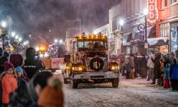 Jack Frost Festival of Lights Parade. A truck decorated with Christmas lights goes down a snowy street for a parade