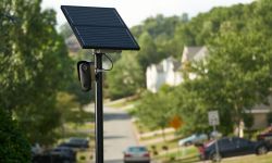 A solar-powered license plate reader mounted on a pole outside