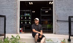 Lucian O'Donnell sits the ground in front of nonprofit United Neighborhood Initiatives' Los HQ