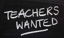 Teachers Wanted is written on a black chalkboard