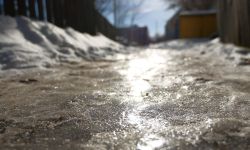 A sidewalk covered in ice and snow. 