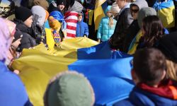 Many people holding an Ukrainian flag. 