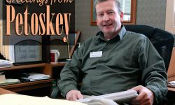 A postcard that says "Greetings From Petoskey" above a picture of John McLintock