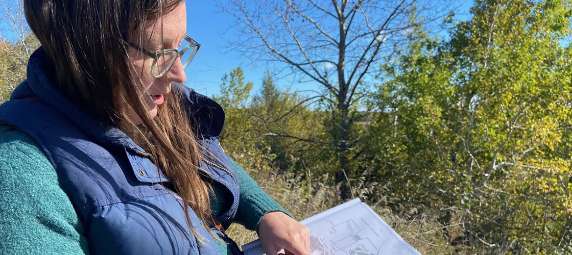 Elise Matz, standing outside, points at a map she's holding